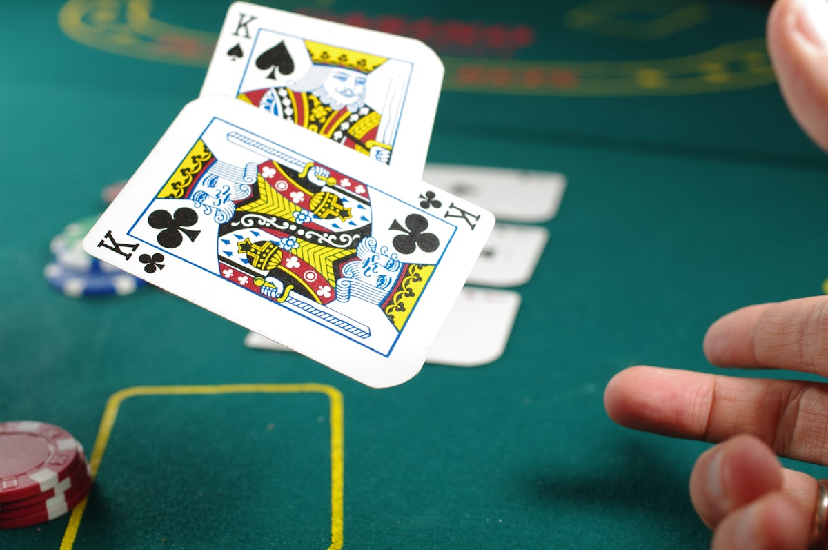 Tangan memegang kartu king di meja poker