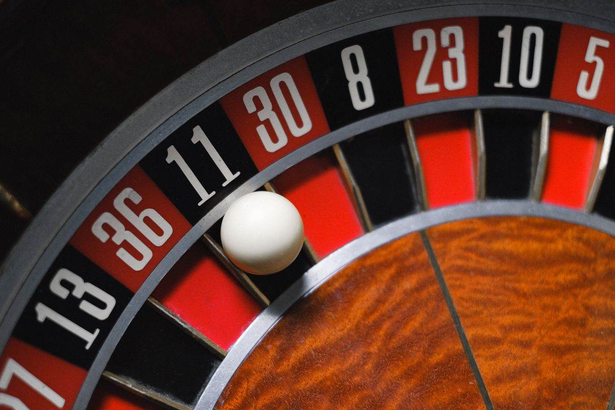 Roda roulette dengan bola di atas meja hijau
