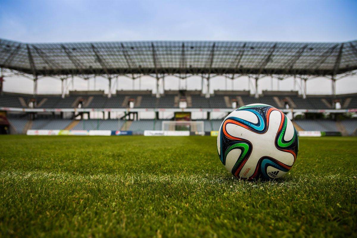 Stadion sepak bola dengan lapangan hijau